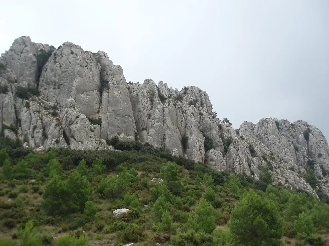 Impresionantes formaciones rocosas en la provincia mas montañosa de España, con vegetación verde en la ladera.