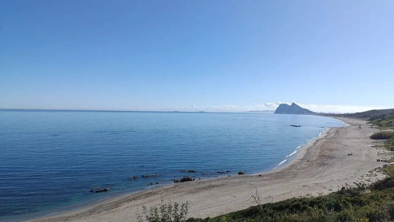 Vista de la playa la Alcaidesa con el Peñón de Gibraltar al fondo. Un día soleado y tranquilo, ideal para disfrutar del mar.