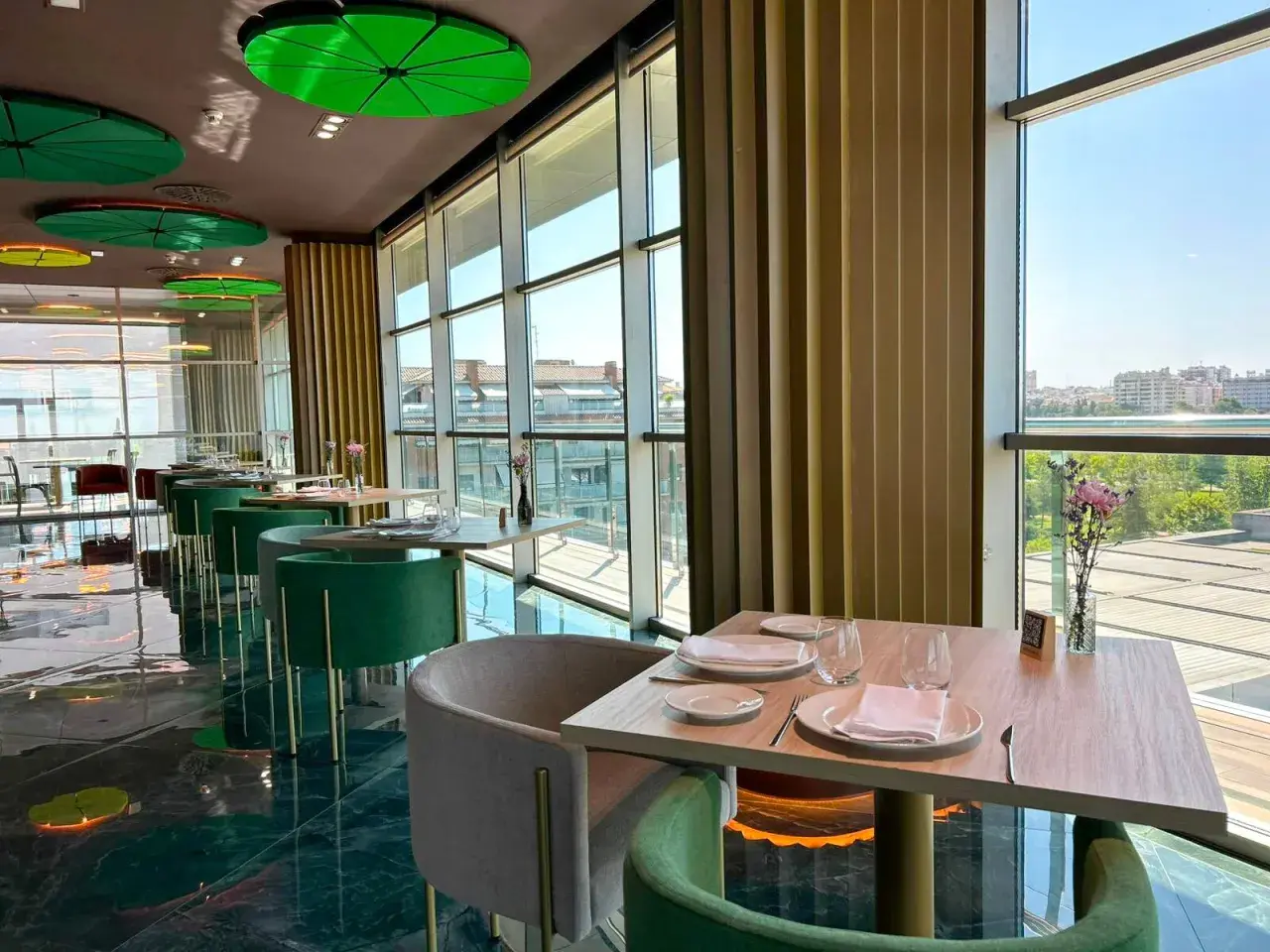 Mesas elegantemente puestas en un restaurante moderno con vistas panorámicas. Un lugar ideal para disfrutar de los mejores restaurantes Badajoz.