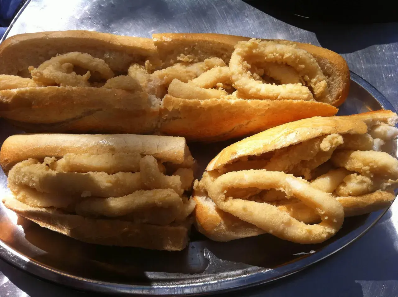 Bocadillos de calamares recién hechos, un clásico del bar El Brillante Madrid, servidos en una bandeja metálica.
