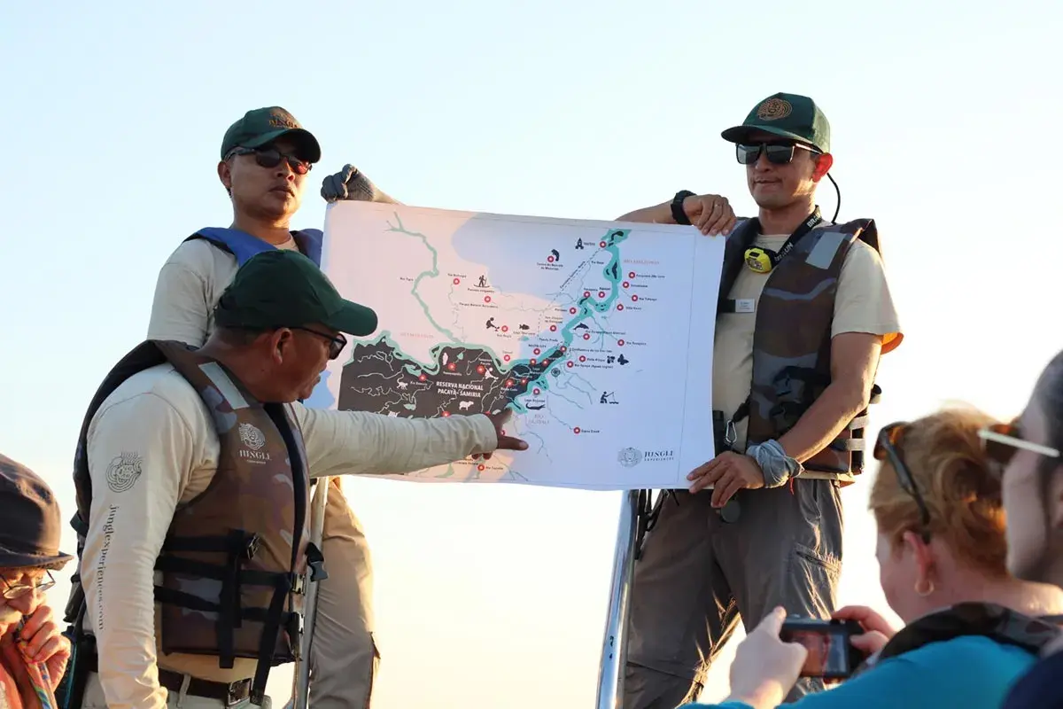 Guías explican un mapa de la Amazonía, compartiendo valiosas opiniones de restaurante amazónico para una aventura inolvidable.