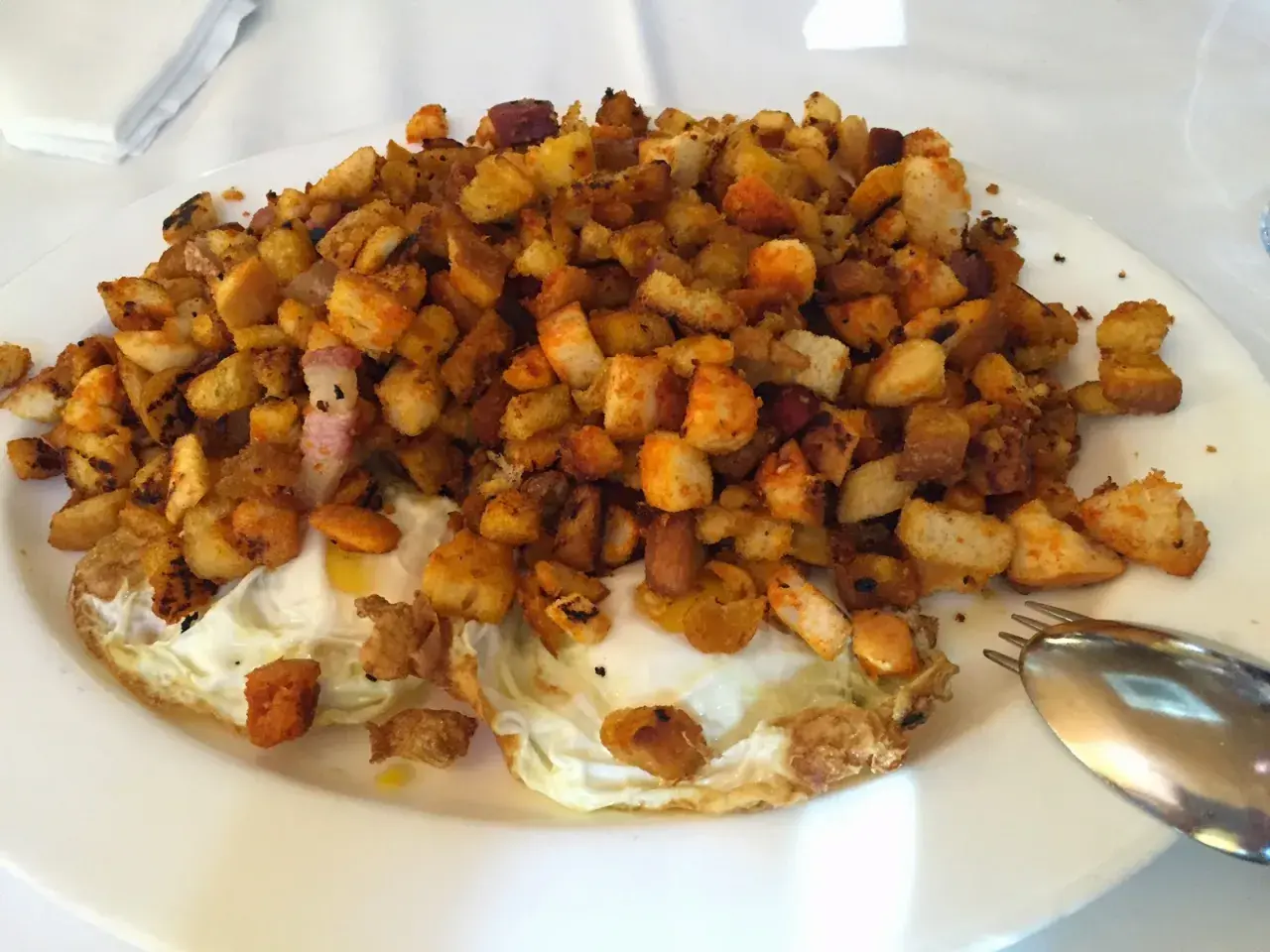 Plato de huevos fritos con patatas y pan tostado, ideal para leer las opiniones de bar restaurante Casa Goyo.