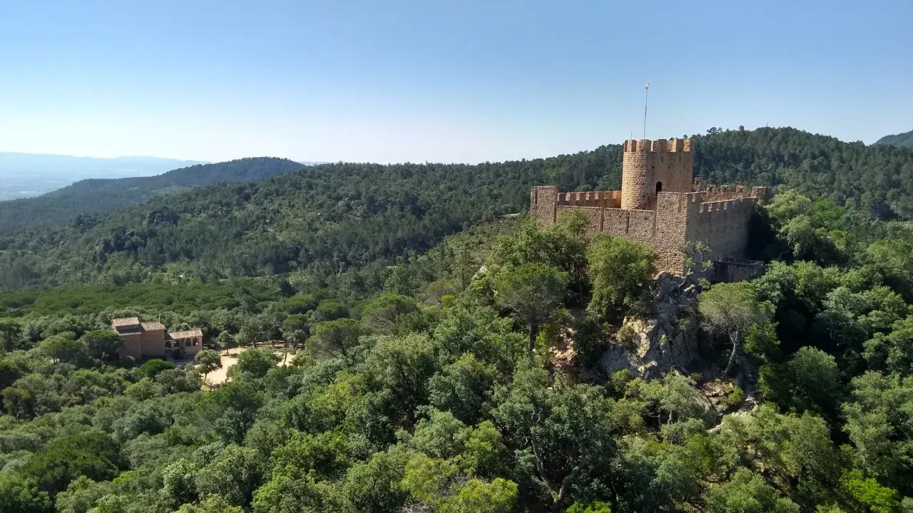 Castillo medieval rodeado de bosques frondosos, con un restaurante en su interior. El Castell de Brunyola ofrece vistas espectaculares.