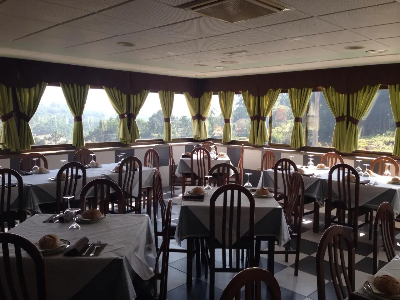 Mesas puestas en uno de los restaurantes en Cangas de Morrazo, con vistas al exterior.