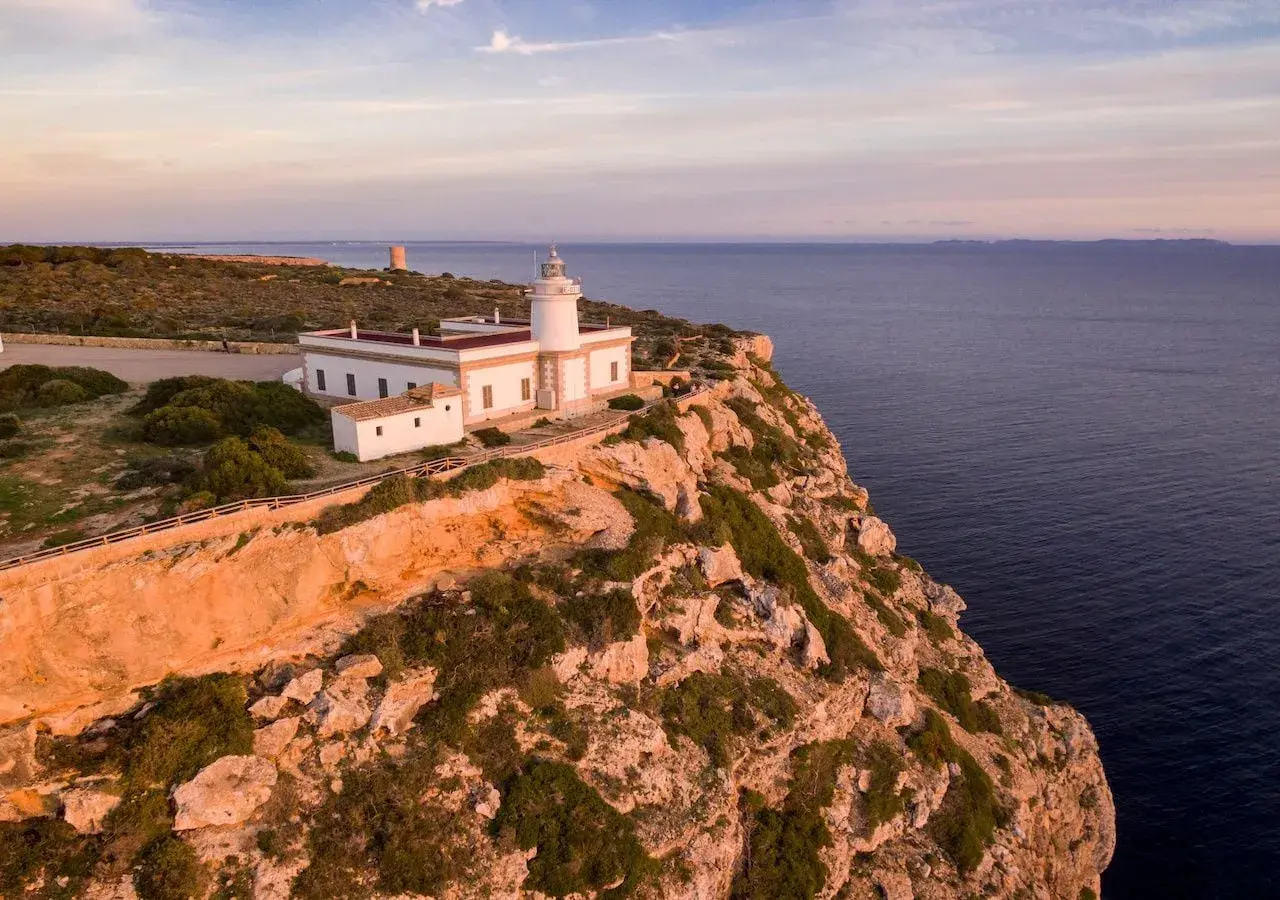 El mirador Sa Foradada, con su faro blanco y el mar azul al atardecer, ofrece vistas espectaculares.