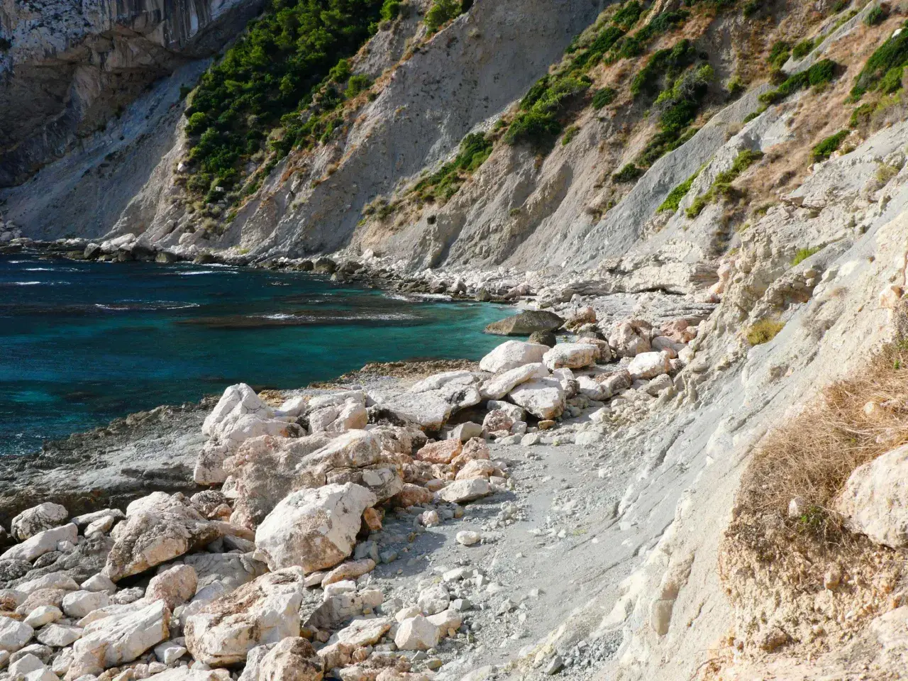 La cala del penyal, con sus aguas turquesas y rocas blancas, invita a la exploración.