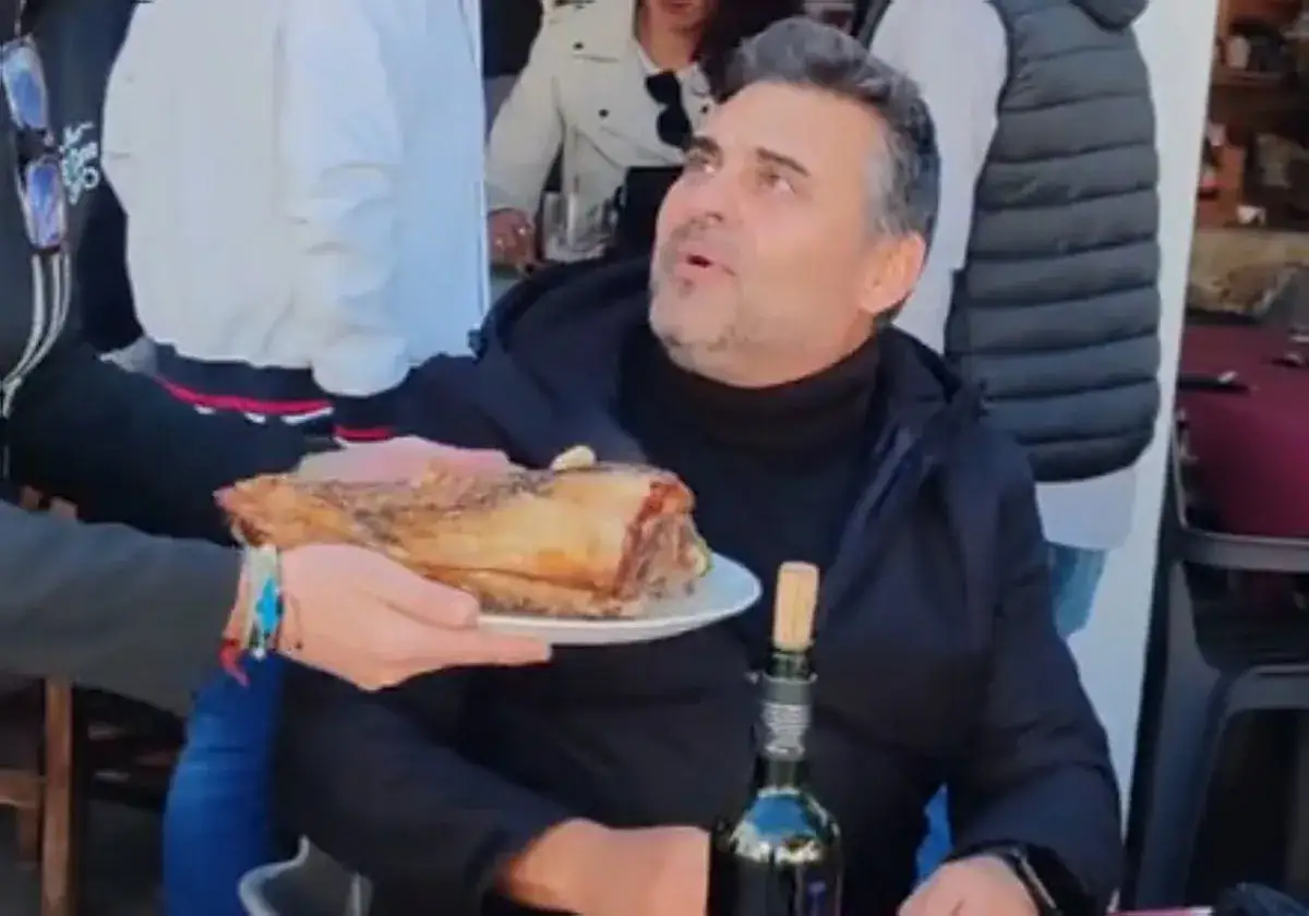 Hombre recibe un plato con carne asada en un mesón. Las fotos del mesón son un tema recurrente.