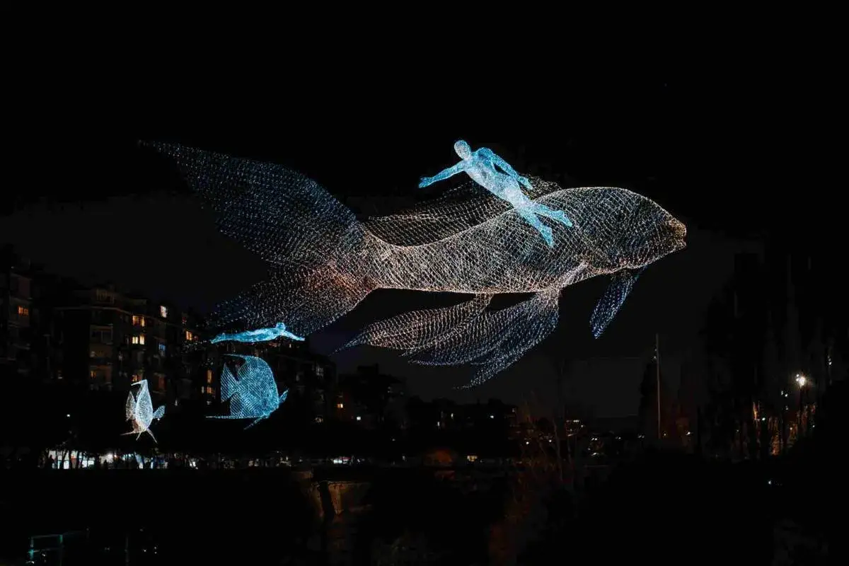 Esculturas luminosas de peces y nadadores flotan en la noche madrile&ntilde;a, como una carrera nocturna de fantas&iacute;a.