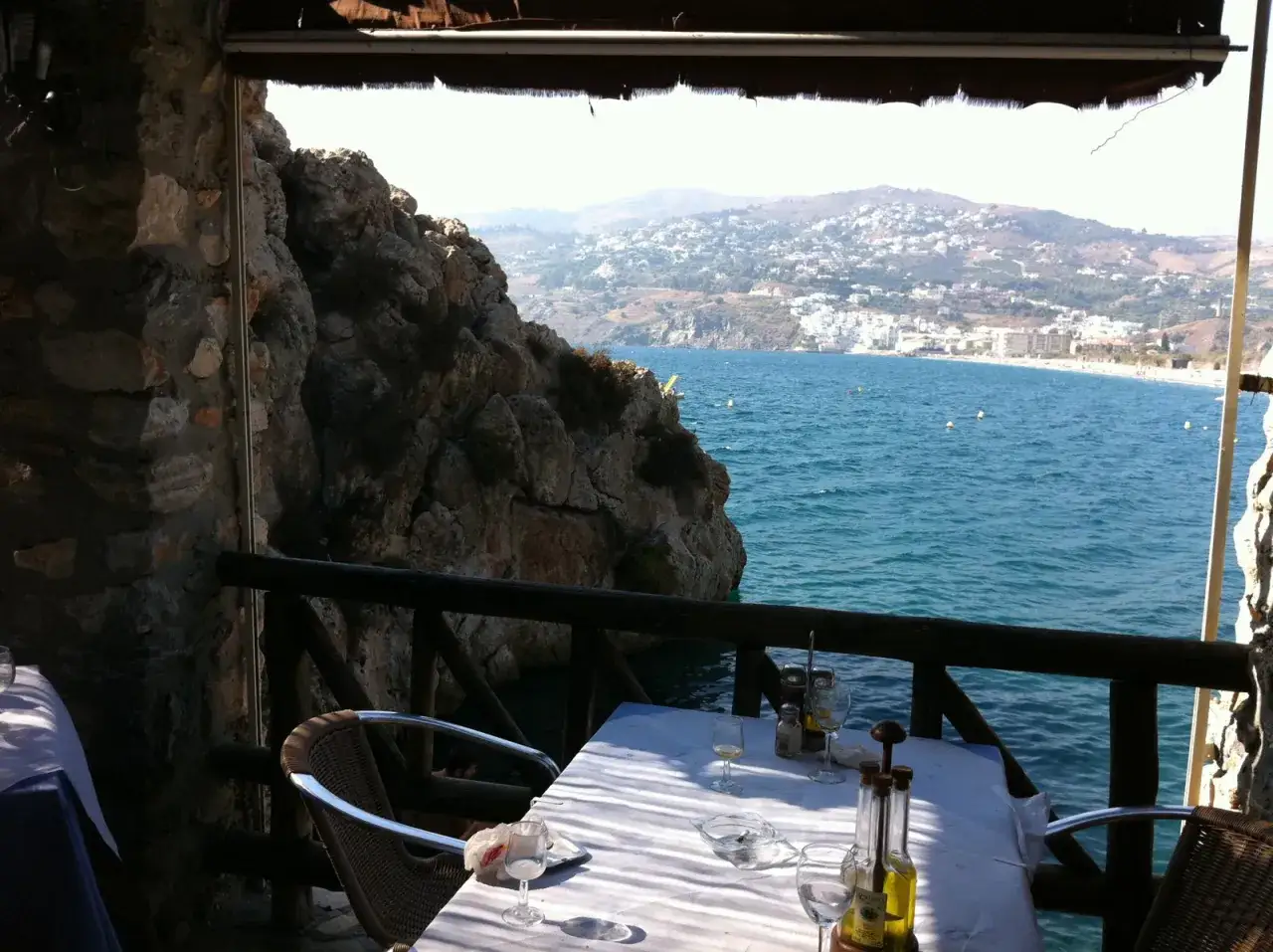 Mesa puesta en restaurante el peñón con vistas al mar. Las reseñas de este lugar prometen una experiencia inolvidable.
