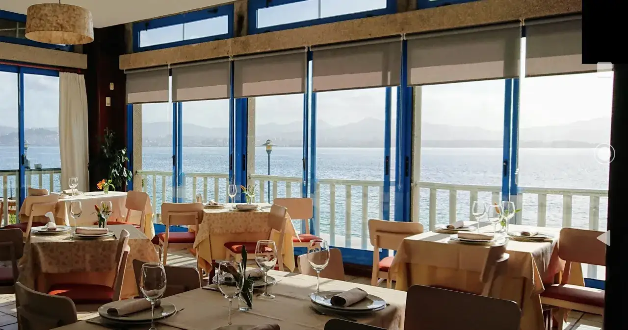 Mesas puestas en restaurantes en Cangas de Morrazo con vistas al mar.