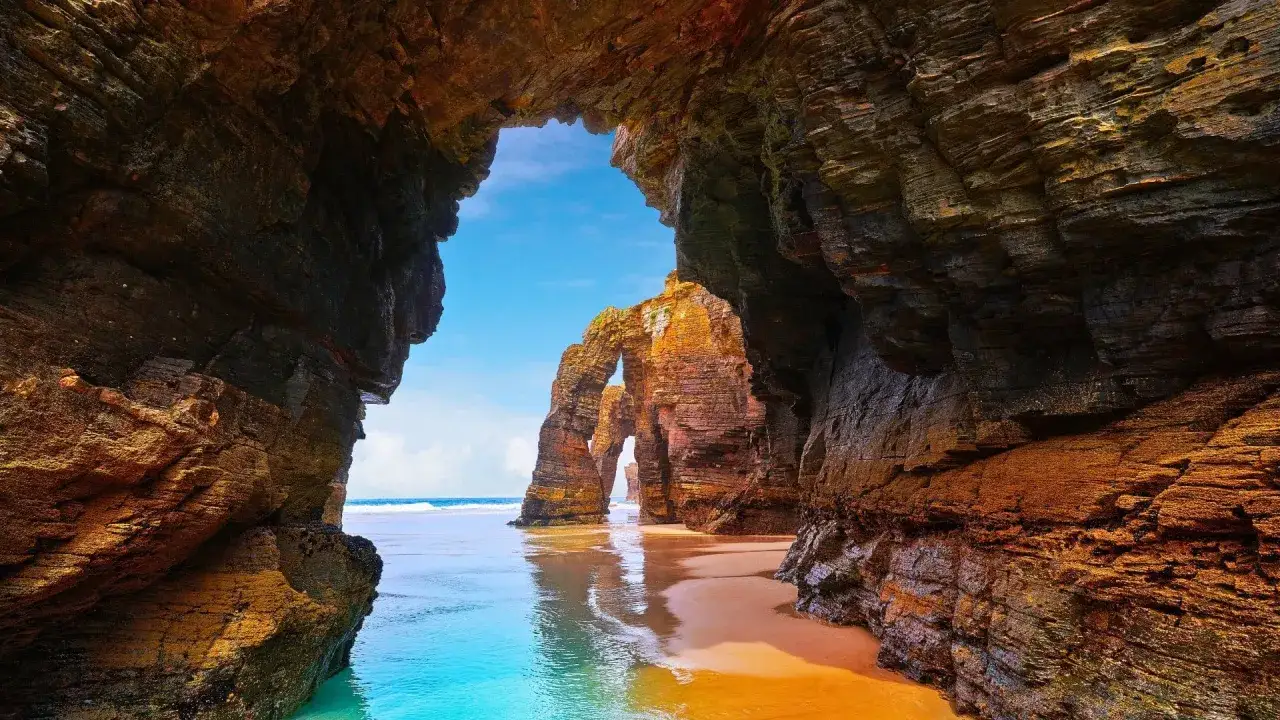 Arco natural en una de las mejores playas de Galicia. Arena dorada, mar turquesa y formaciones rocosas espectaculares.