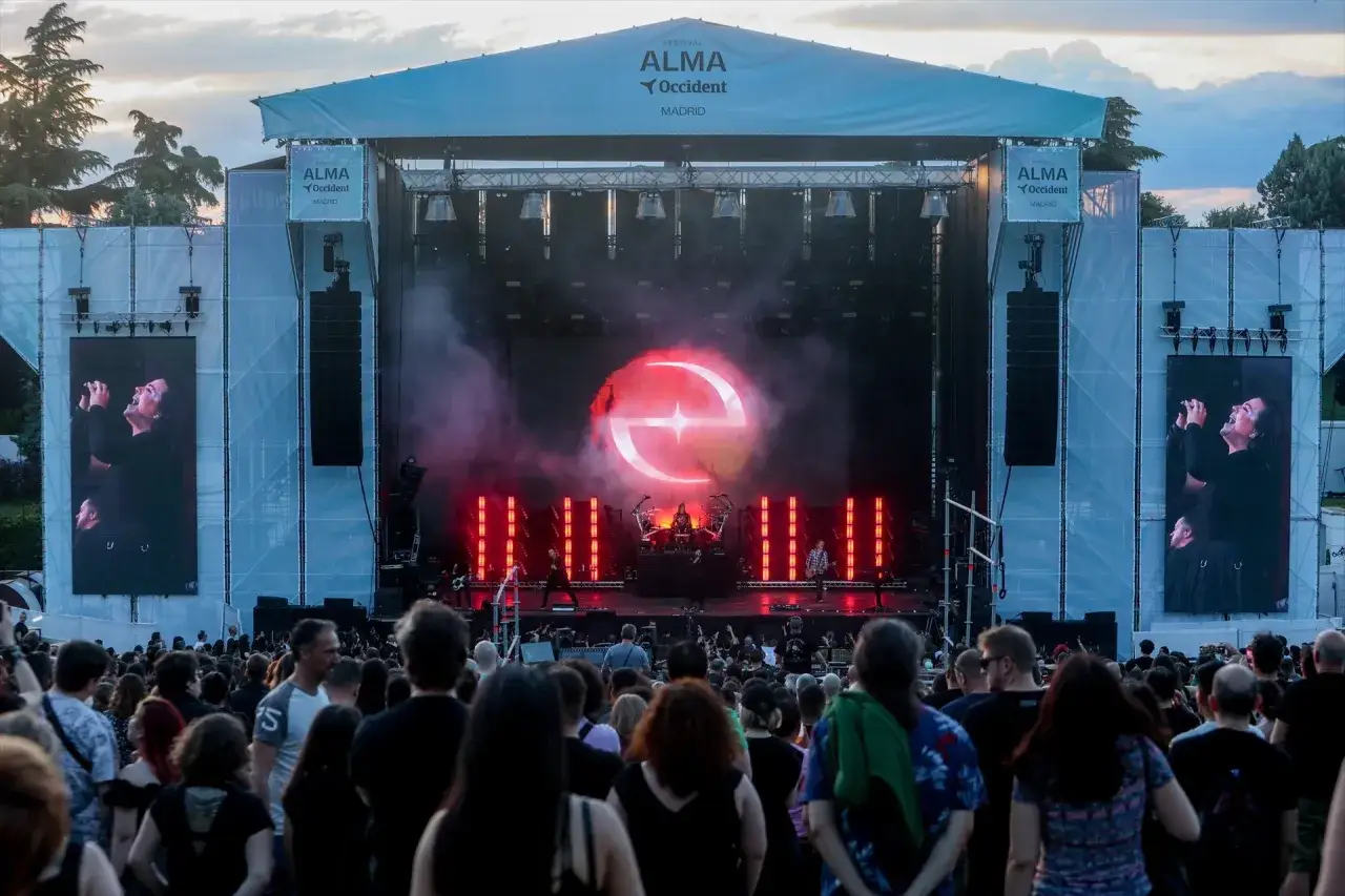 Multitud en el alma festival madrid, disfrutando de un concierto con luces rojas y un gran logo en la pantalla.
