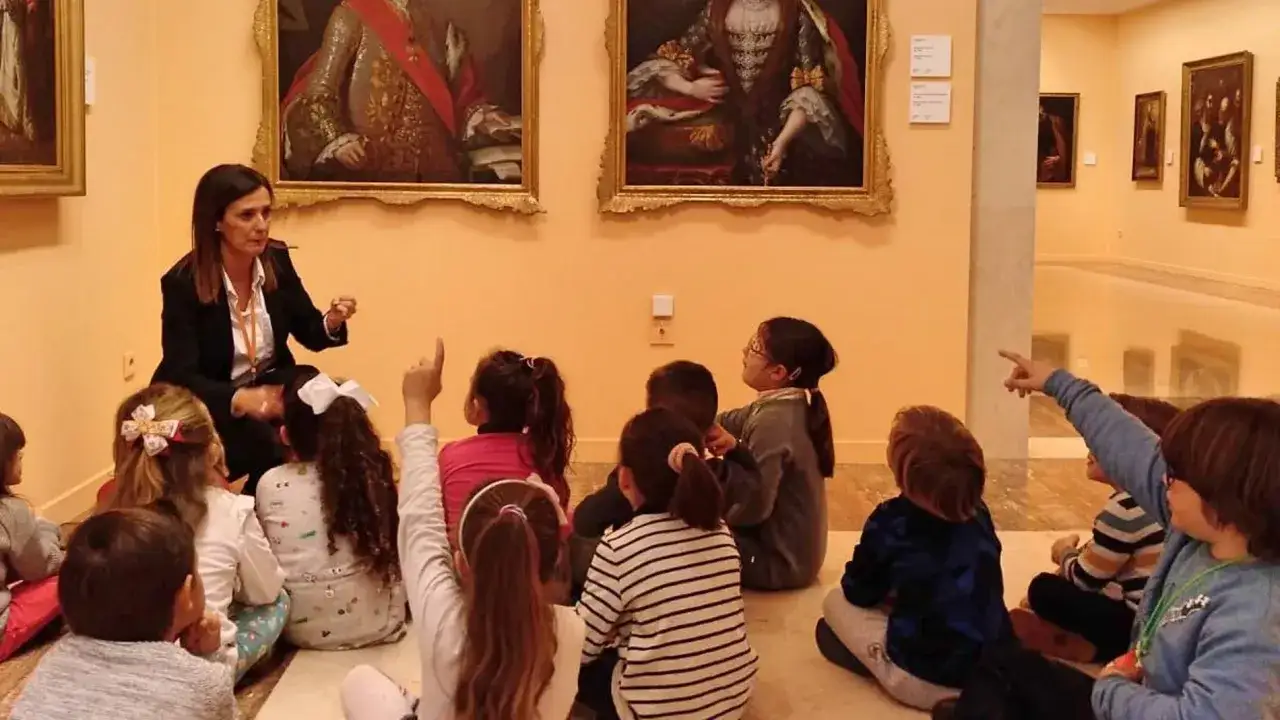 Ni&ntilde;os atentos en un museo, aprendiendo sobre arte en el 18 de mayo d&iacute;a de los museos.