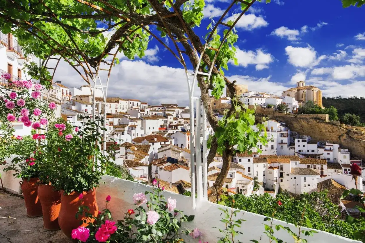 Vista de un pueblo blanco andaluz, parte de la ruta pueblos blancos Cádiz, con flores rosas y enredaderas.