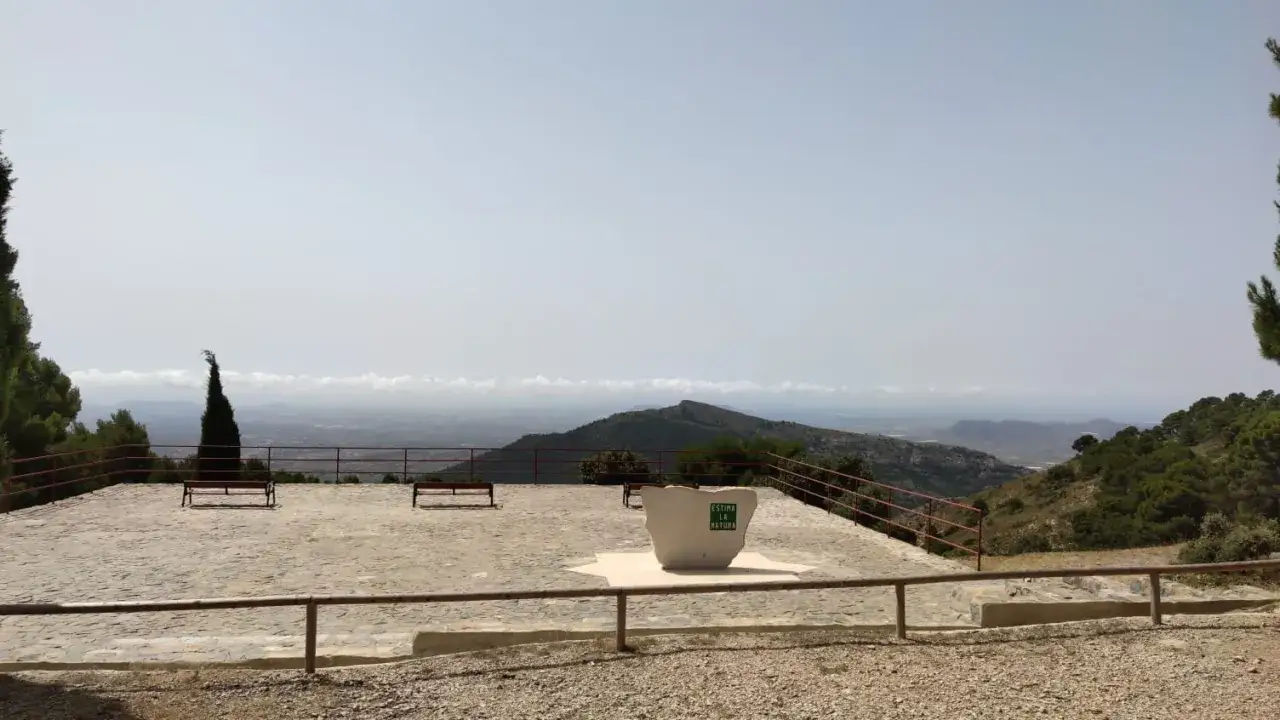 Un mirador con bancos y una escultura que dice