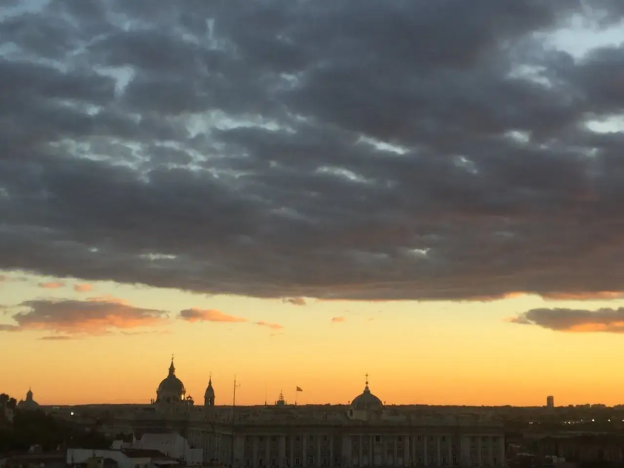Atardecer sobre Madrid desde el ginkgo restaurante & sky bar. Nubes oscuras y doradas sobre la ciudad.