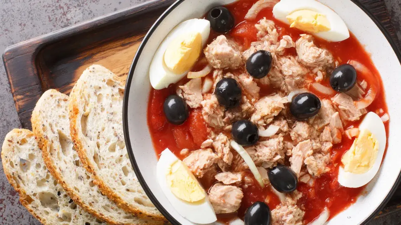 Ensalada de atún con tomate, huevo duro y aceitunas negras, un plato típico de los restaurantes en la huerta de Murcia, servida con pan rústico.