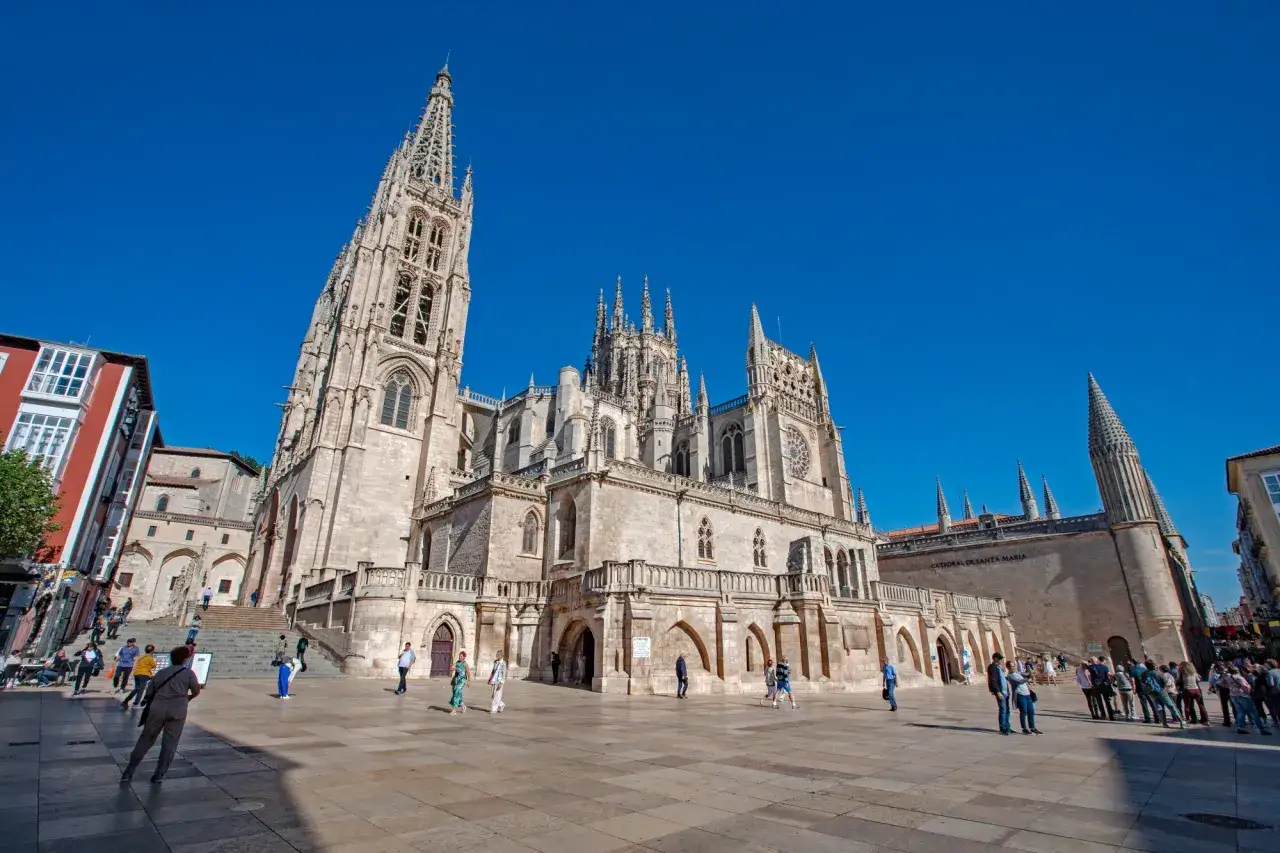 La Catedral de Burgos, un lugar perfecto para visitar con niños, se alza majestuosa bajo un cielo azul intenso.