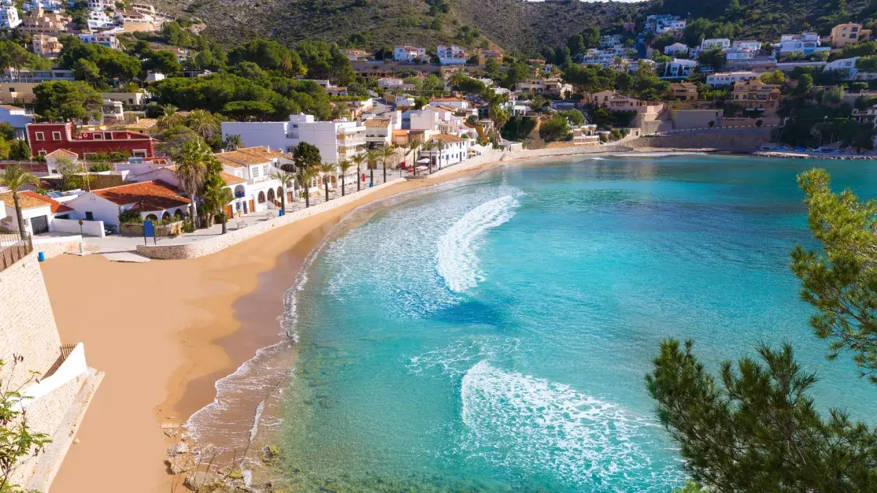 La id&iacute;lica cala el Portet, con su arena dorada, aguas turquesas y casas blancas, se asoma al Mediterr&aacute;neo.