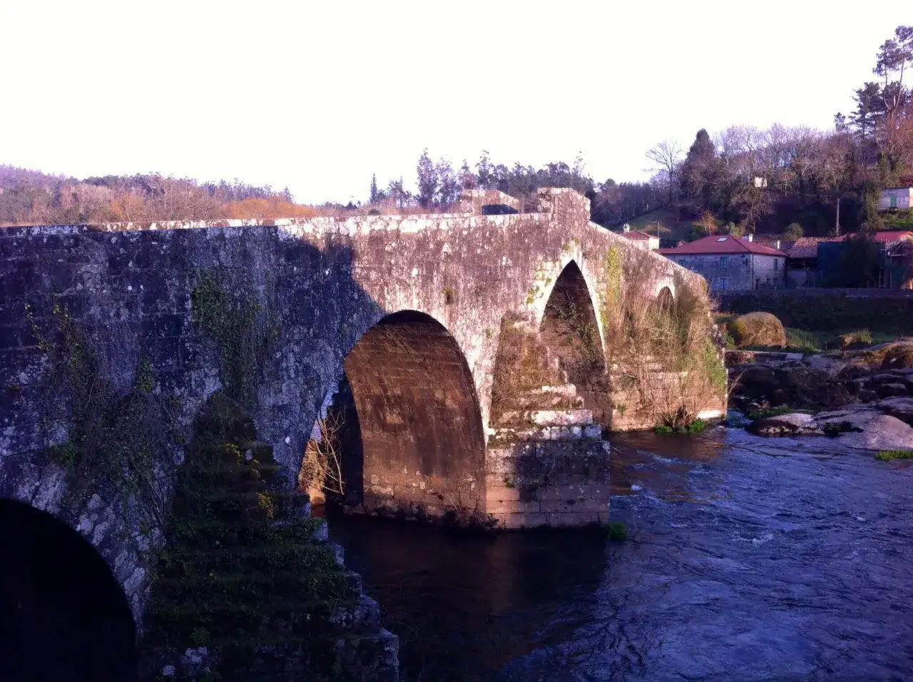 Puente de piedra antiguo sobre río. Para llegar a Ponte Maceira, sigue el curso del agua.