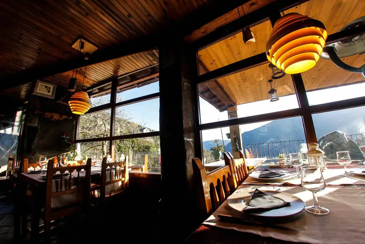 Mesas puestas con vistas a la monta&ntilde;a, ideal para saber donde comer en Broto. Ambiente r&uacute;stico y acogedor.