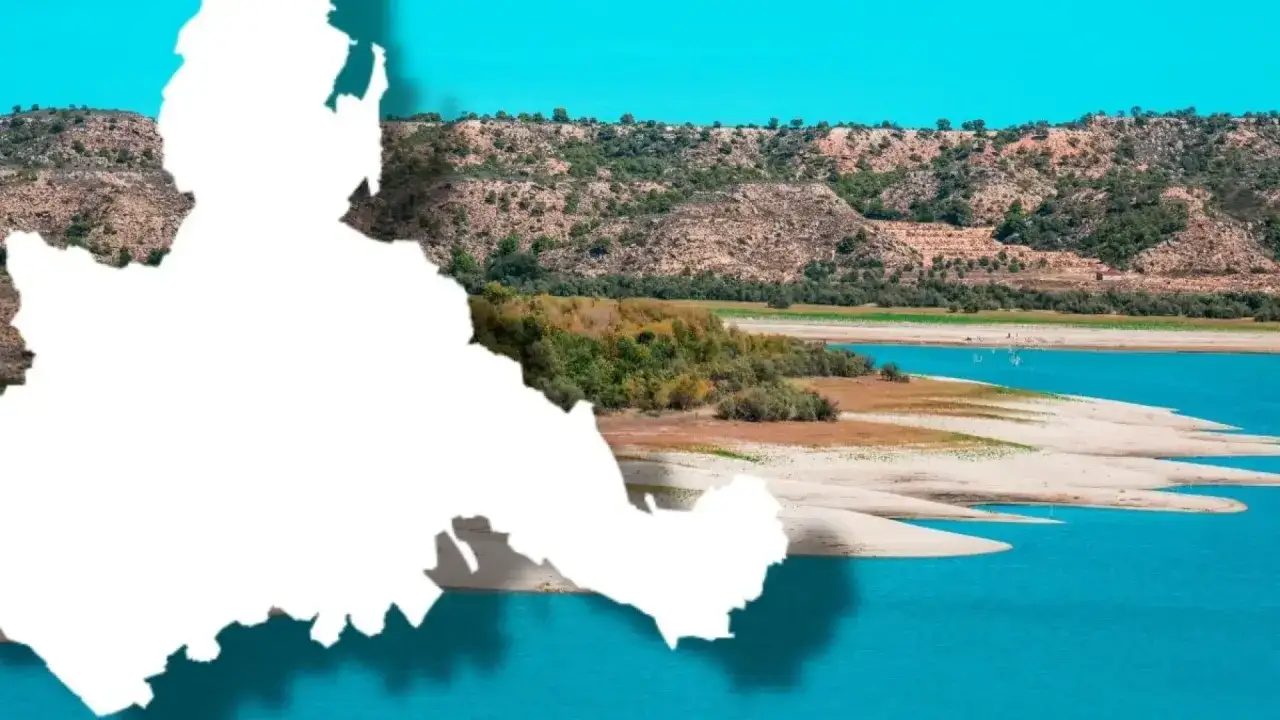 Paisaje de embalse con playas de arena y colinas verdes, un oasis inesperado entre las playas cerca de Zaragoza.