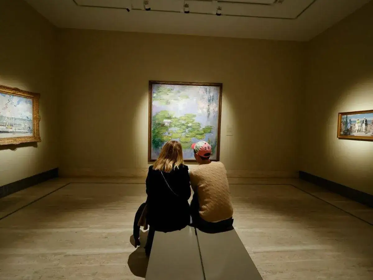 Dos personas contemplan un cuadro de nenúfares en la noche de los museos.